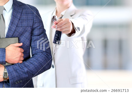 Woman offering a car key. Man holding documents 26691713
