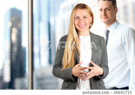 Business woman and man standing near window Business woman and man standing near window 26691715