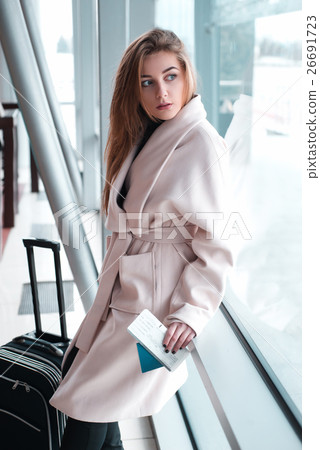 Businesswoman with baggage poses at the airport. Businesswoman with baggage poses at the airport. 26691723