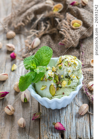 White bowl with pistachio ice cream and mint. 26693242