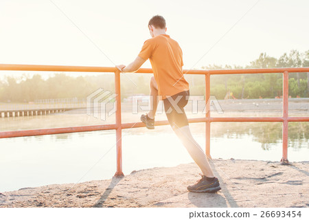 Fitness man stretching his leg muscles outdoors. Fitness man stretching his leg muscles outdoors. 26693454