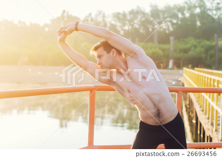 Young athlete man doing side bend exercise. 26693456
