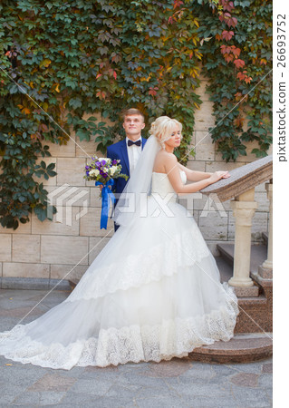 Stylish newlyweds posing for a walk in the photo Stylish newlyweds posing for a walk in the photo 26693752