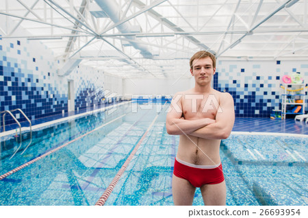 Portrait of swimmer standing with arms crossed at Portrait of swimmer standing with arms crossed at 26693954