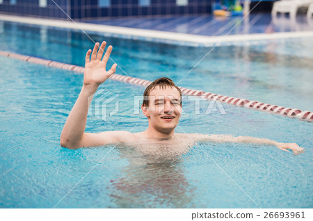Young happy man in the swimming pool with one hand Young happy man in the swimming pool with one hand 26693961