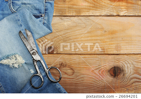 Jeans and scissor on wooden background dark tone Jeans and scissor on wooden background dark tone 26694201