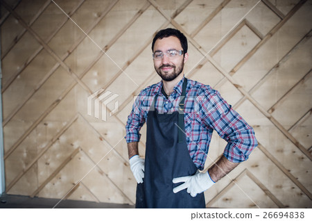 Young male carpenter wearing gloves and glasses Young male carpenter wearing gloves and glasses 26694838
