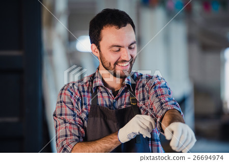 Happy young handyman carpenter in workshop 26694974