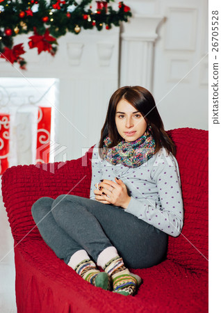 Beautiful girl is warming near fireplace while Beautiful girl is warming near fireplace while 26705528