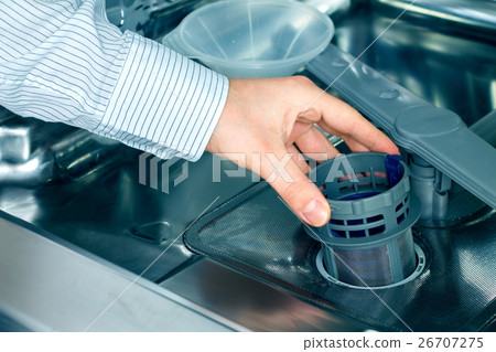 Man's hand taking out a dishwasher filter 26707275