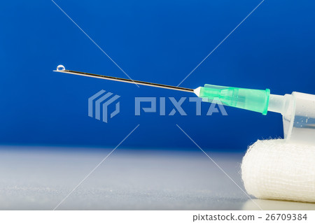 Syringe on gauze with drop on top of needle 26709384