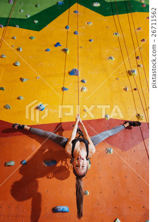 Joyful woman making a trick on climbing wall Joyful woman making a trick on climbing wall 26711562