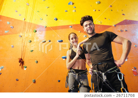 Overjoyed man and woman posing in climbing gym. 26711708