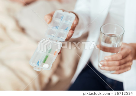 Pleasant professioanl nurse holding pills Pleasant professioanl nurse holding pills 26712554