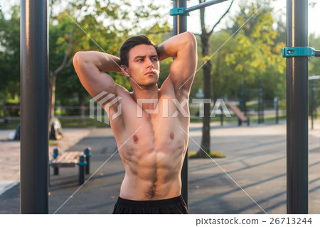 Fitnes man posing on street fitness station Fitnes man posing on street fitness station 26713244