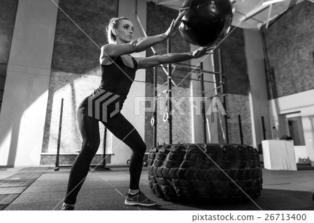 Sporty nice woman throwing a medicine ball Sporty nice woman throwing a medicine ball 26713400