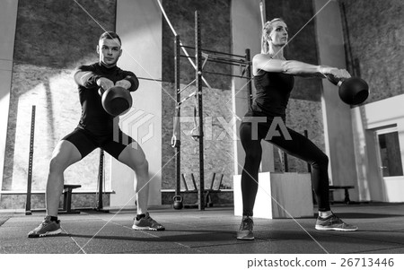 Athletic workout partners holding kettlebells in Athletic workout partners holding kettlebells in 26713446