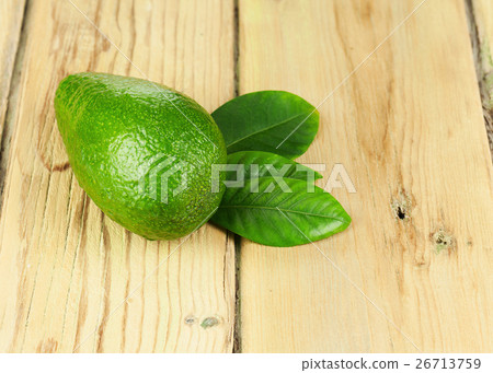 Ripe Green Avocado with Leaves on Wooden Background. 26713759