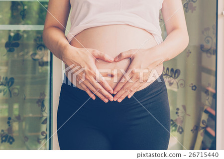 Pregnant Woman holding hand heart shape for baby Pregnant Woman holding hand heart shape for baby 26715440