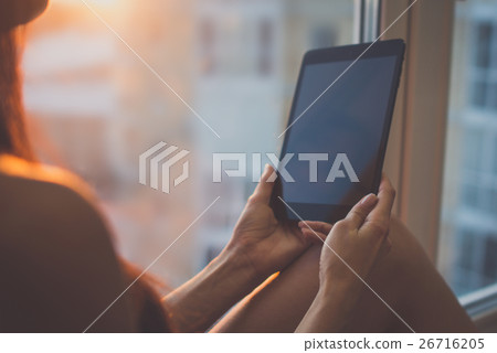 Woman using digital tablet at home sitting near Woman using digital tablet at home sitting near 26716205