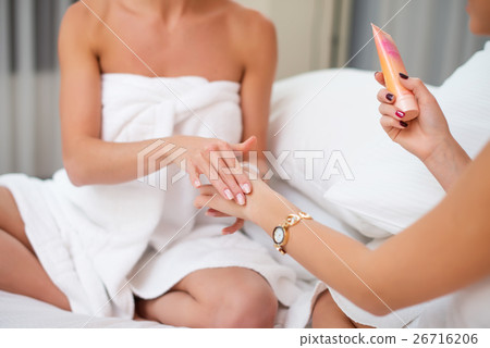 Two woman applying cosmetic hand cream home spa. Two woman applying cosmetic hand cream home spa. 26716206