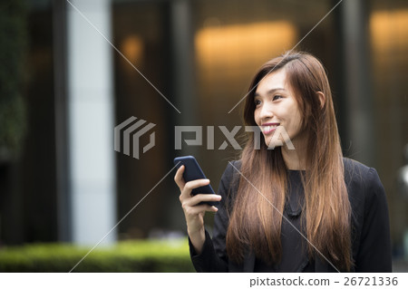 Asian businesswoman using her smart phone. Asian businesswoman using her smart phone. 26721336