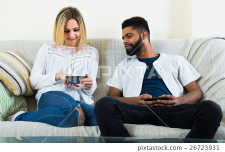 man and woman sitting on sofa 26723931