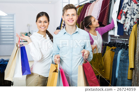 Spouses carrying bags in boutique 26724059