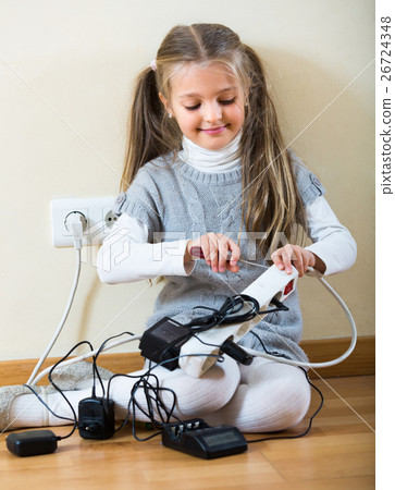 Little girl playing with sockets at home. Little girl playing with sockets at home. 26724348