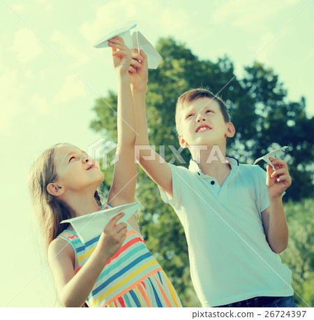 two little kids playing with simple paper planes 26724397