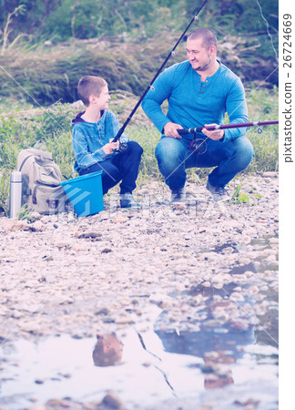 Young father and boy fishing with rods 26724669