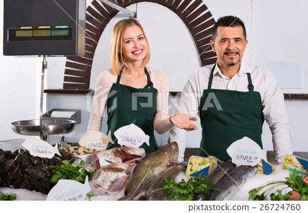 Positive smiling shop assistants selling fresh fish 26724760