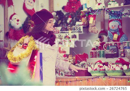 Girl choosing Christmas decoration at market. 26724765