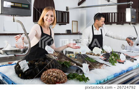 Two sellers in fish section of supermarket. Two sellers in fish section of supermarket. 26724792