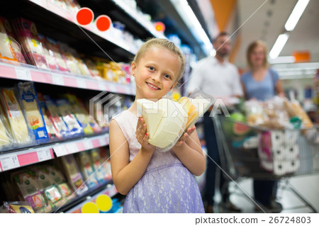 Girl holding cheese in hands in supermarket. Girl holding cheese in hands in supermarket. 26724803
