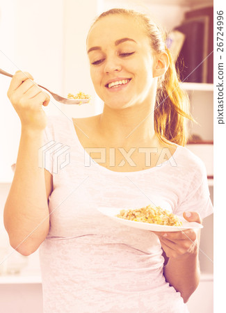 portrait of young woman eating mush at kitchen portrait of young woman eating mush at kitchen 26724996