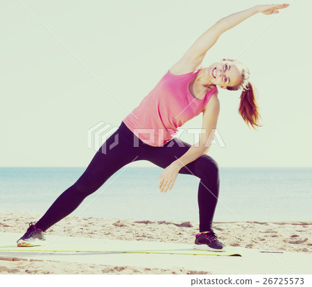 Girl in sportswear practice yoga at sea beach Girl in sportswear practice yoga at sea beach 26725573