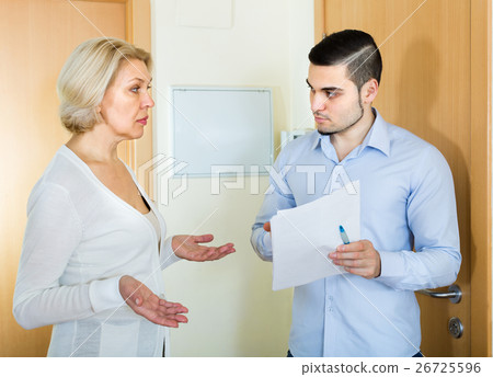 Serious man and housewife at the door 26725596