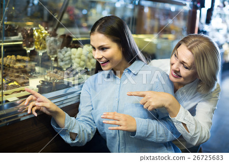 women buying dark and white chocolate filled candies women buying dark and white chocolate filled candies 26725683