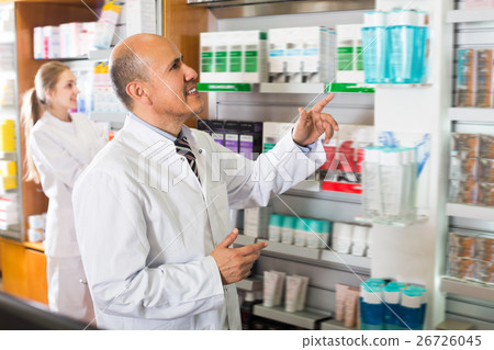 Pharmacist and pharmacy assistant helping 26726045