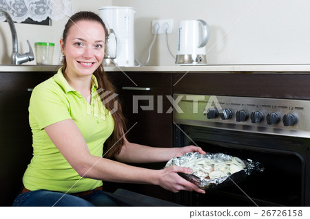 Happy woman cooking fish Happy woman cooking fish 26726158