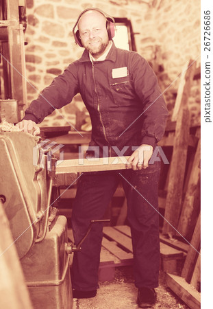 Woodworker on lathe in workroom Woodworker on lathe in workroom 26726686