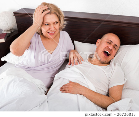 Mature tired girl looking at snoring boyfriend 26726813