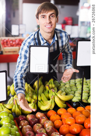 Grocery worker selling seasonal fruits 26726868
