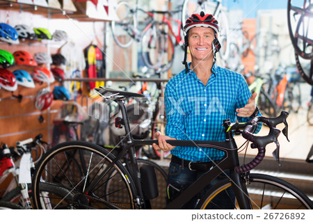 Smiling man customer picking new chosen bicycle 26726892