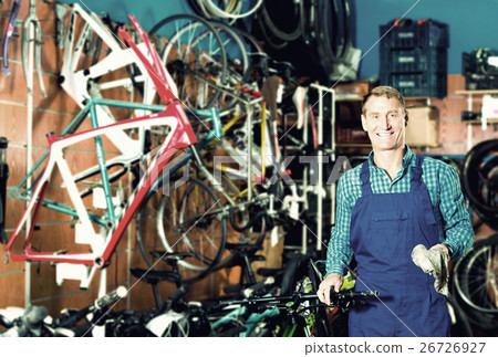 Male seller in uniform picking new bicycle wheel hands Male seller in uniform picking new bicycle wheel hands 26726927