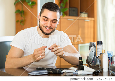 Man doing manicure at home Man doing manicure at home 26726947