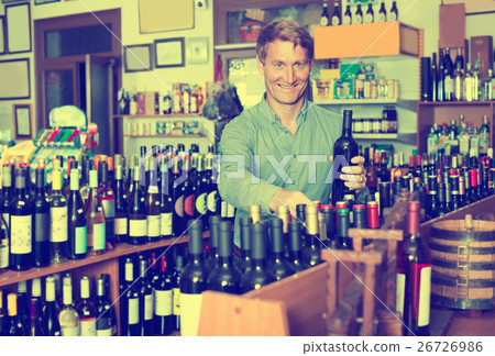 customer picking bottle in wine store. 26726986