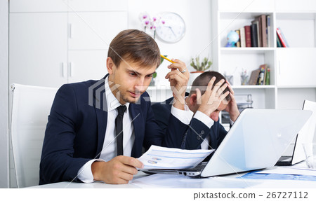 Two sad young men coworkers in firm office Two sad young men coworkers in firm office 26727112