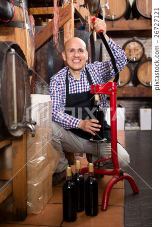 Man wearing apron using bottle corking apparatus Man wearing apron using bottle corking apparatus 26727121